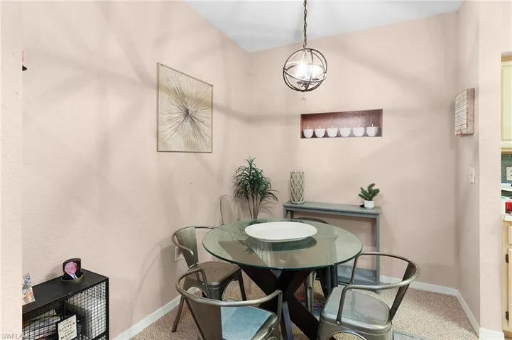 Carpeted dining area featuring an inviting chandelier