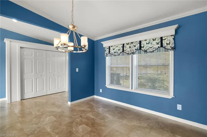 Unfurnished dining area with vaulted ceiling, crown molding, and a notable chandelier