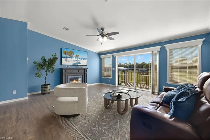 Living room featuring ceiling fan, ornamental molding, and hardwood / wood-style flooring, partially staged virtually