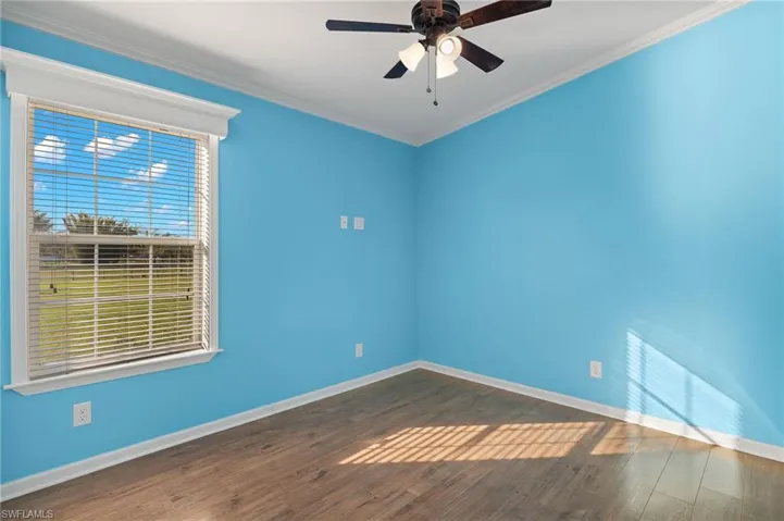 Unfurnished room featuring ceiling fan, dark hardwood / wood-style flooring, and crown molding