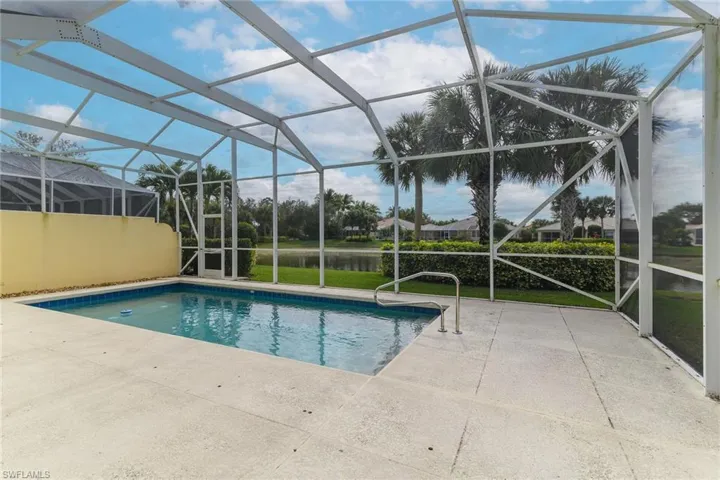 Outdoor pool featuring a sunroom, a lanai, a patio area, and a water view