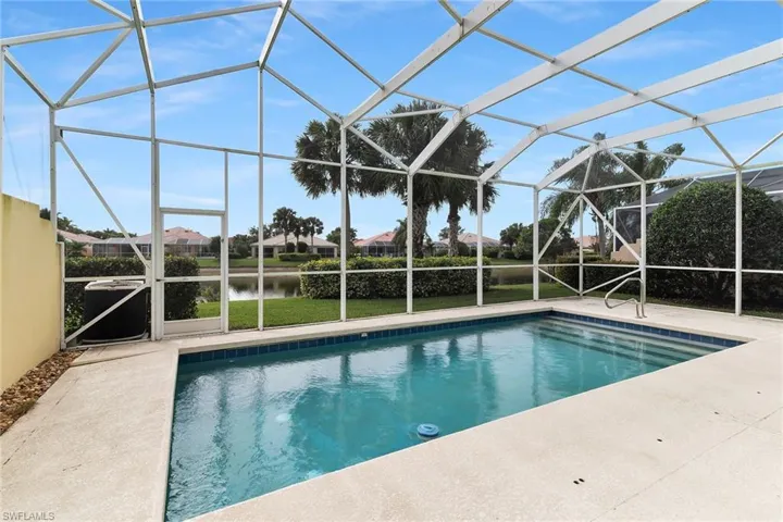 Swimming pool featuring a sunroom, a lanai, a patio area, a water view, and a residential view