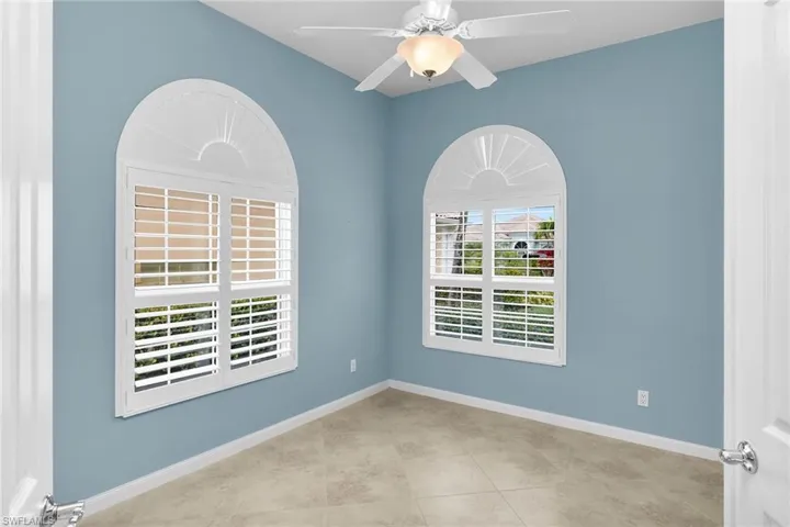 Spare room with a ceiling fan and light tile patterned floors