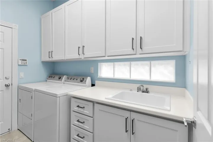 Laundry area featuring washing machine and dryer and cabinet space