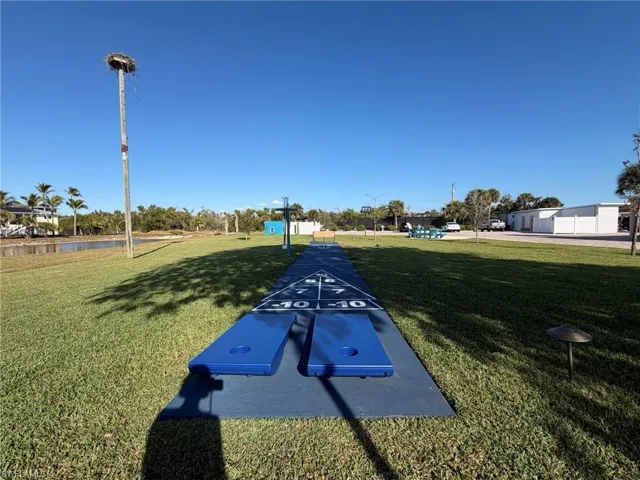 View of property's community with shuffleboard and a water view