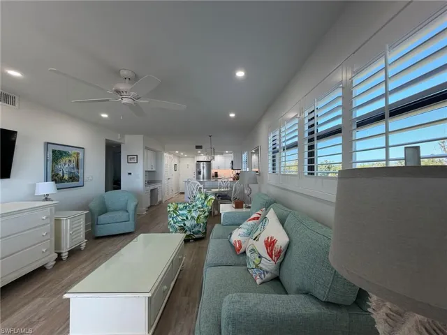 Living room with wood finished floors, ceiling fan, and recessed lighting