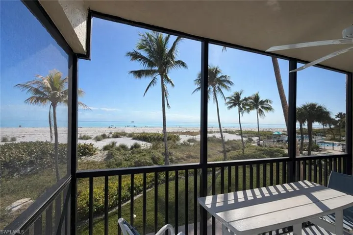 Sunroom with view of water and beach