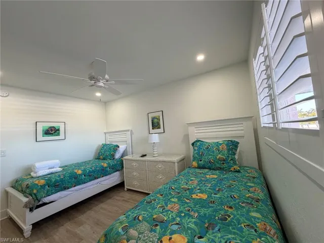 Bedroom with wood finished floors, ceiling fan, and recessed lighting