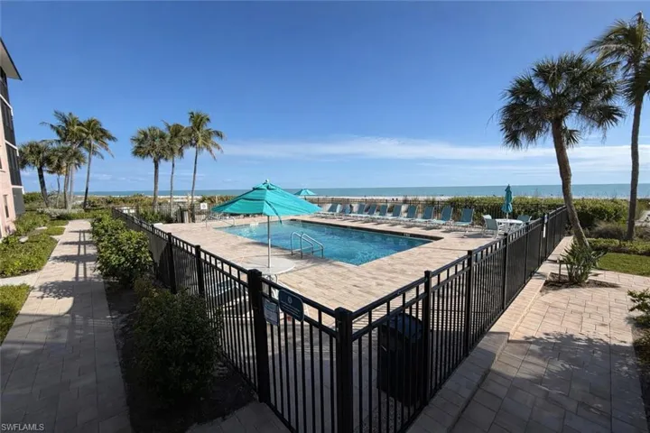 Community pool featuring a water view and a patio area