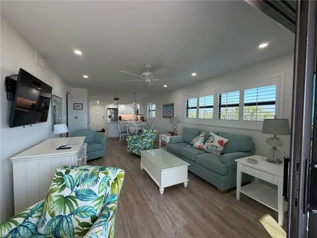 Living room with wood finished floors, recessed lighting, and a ceiling fan