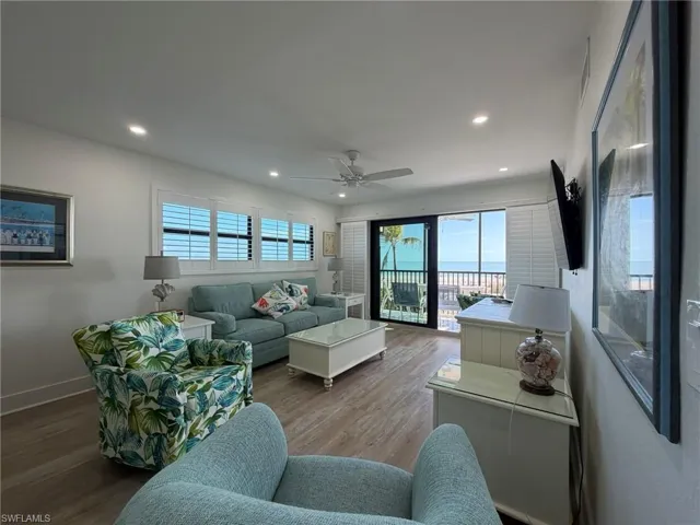 Living area with wood finished floors, healthy amount of natural light, ceiling fan, and recessed lighting