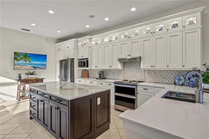 Kitchen featuring a center island, sink, white cabinets, and appliances with stainless steel finishes