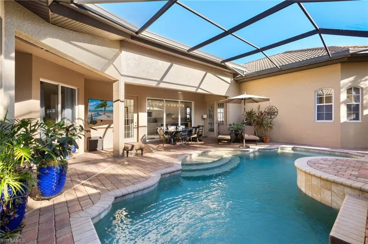 View of pool featuring a patio and glass enclosure