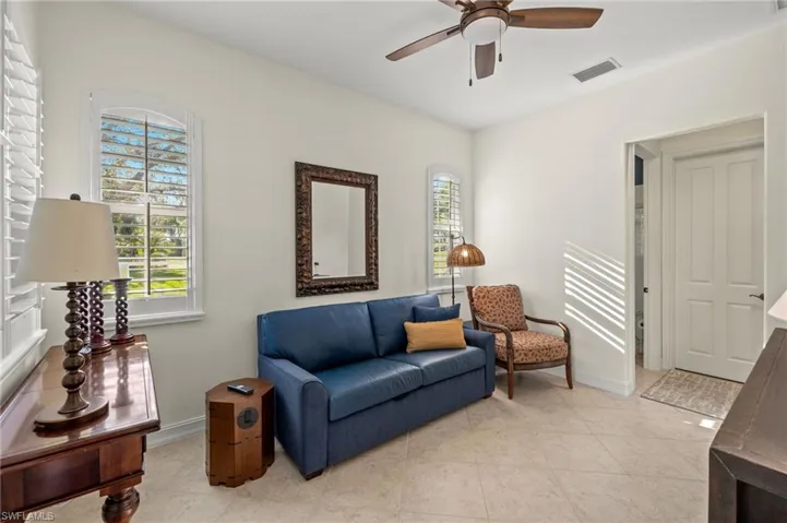 Living room with light tile patterned floors and ceiling fan