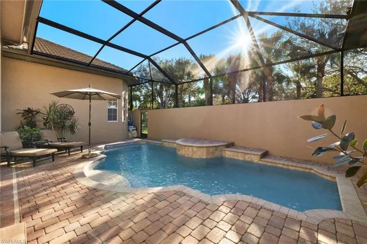 View of pool with a patio area and a lanai