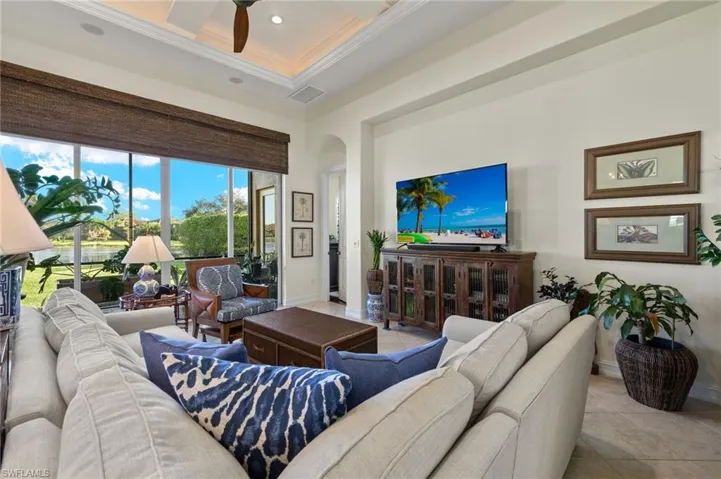 Living room featuring ceiling fan, light tile patterned floors, and ornamental molding