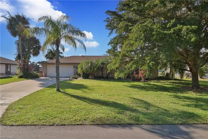 View of front of property featuring a garage and a front yard