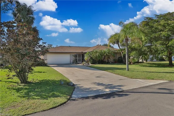 View of front of property featuring a garage and a front yard