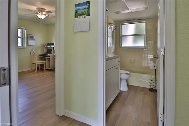 Full bathroom with vanity, a healthy amount of sunlight, hardwood / wood-style floors, and toilet