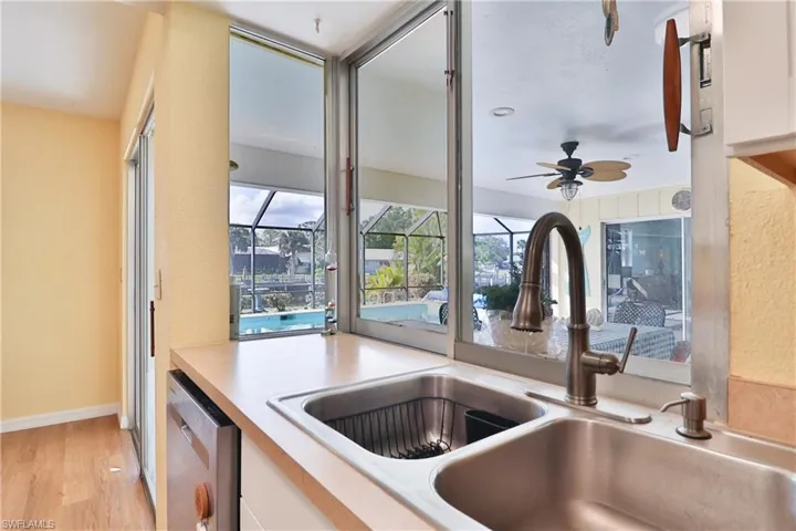 Kitchen featuring sink, white cabinetry, light hardwood / wood-style flooring, dishwasher, and ceiling fan