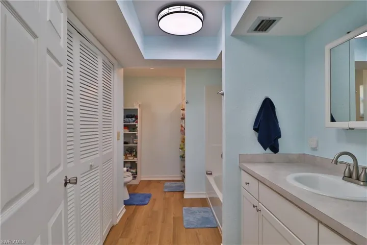 Full bathroom featuring hardwood / wood-style flooring, vanity, bathing tub / shower combination, and toilet