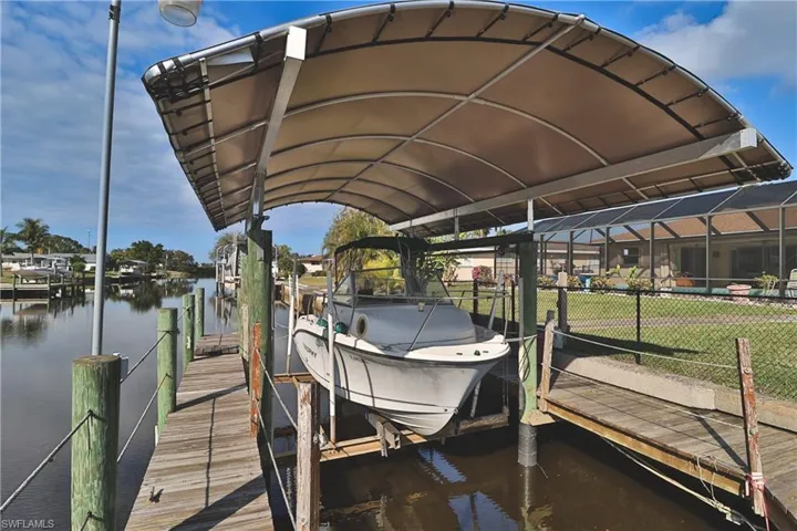 Dock area with a water view and glass enclosure