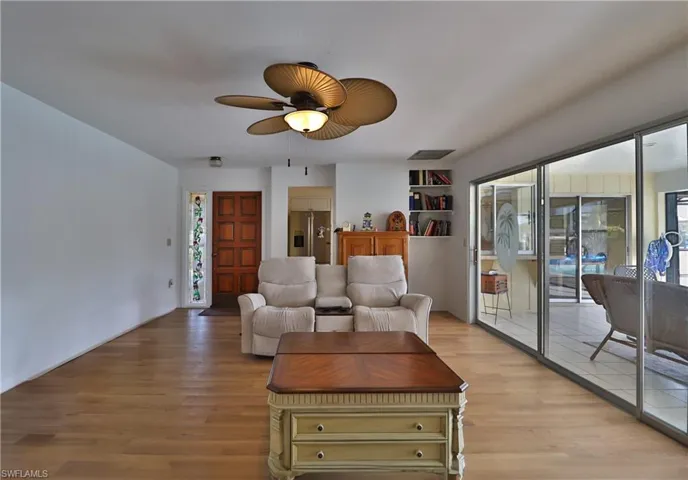 Living room with ceiling fan and light wood-type flooring