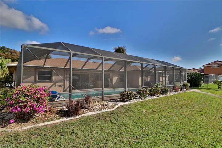 View of pool with a lanai and a yard