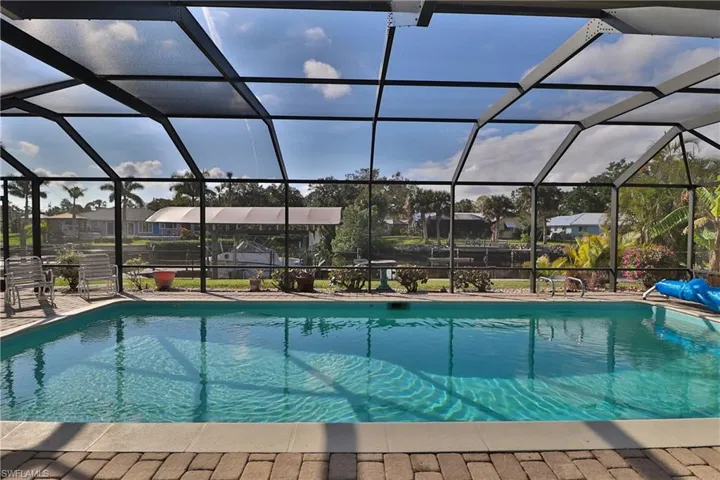 View of pool with a patio and glass enclosure
