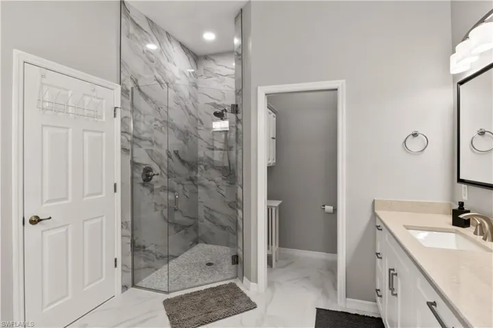 Bathroom with a shower with shower door and vanity
