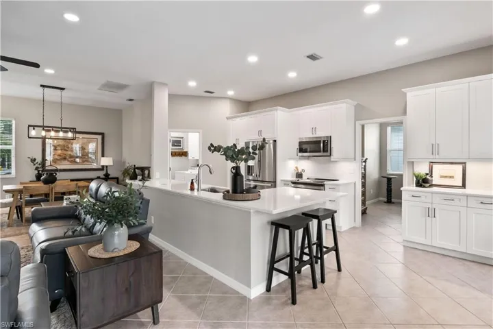 Kitchen with white cabinets, appliances with stainless steel finishes, ceiling fan, and sink