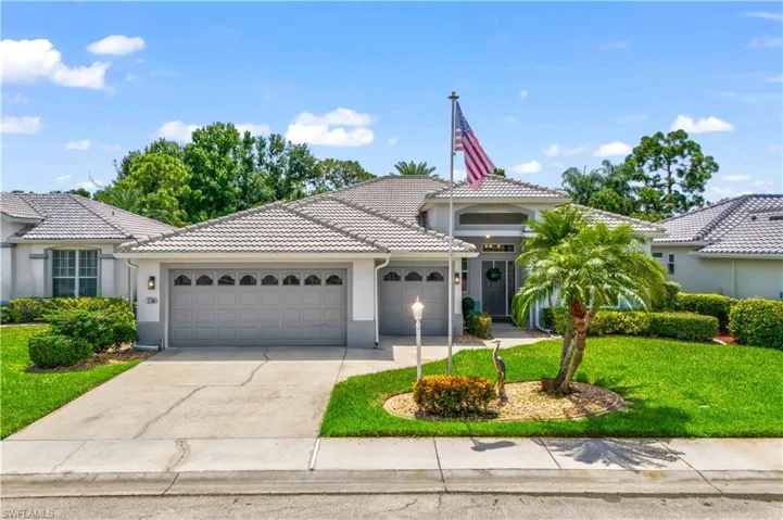 View of front of property with a garage and a front lawn