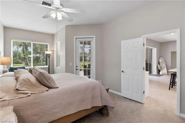 Tiled bedroom featuring ceiling fan and access to exterior