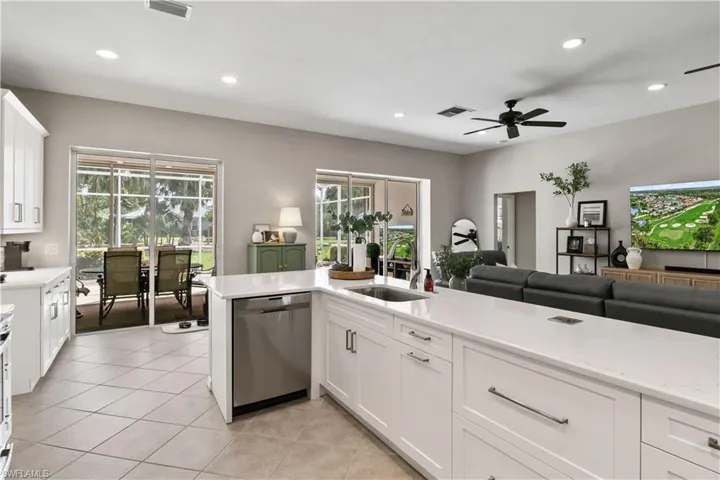 Kitchen featuring white cabinets, ceiling fan, dishwasher, and sink