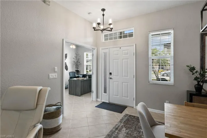 Tiled foyer featuring a notable chandelier
