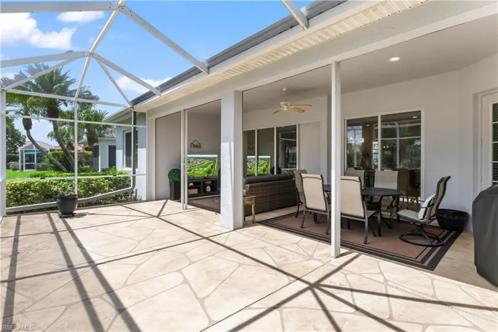 View of patio with ceiling fan and a lanai