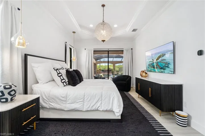Interior space with a tray ceiling and a large glass door opening to an outdoor area