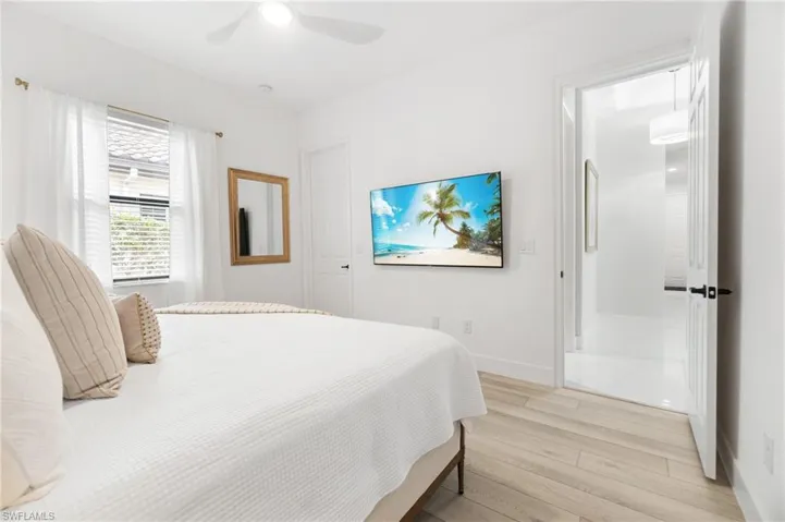 Bright room featuring light wood-finish flooring and a ceiling fan