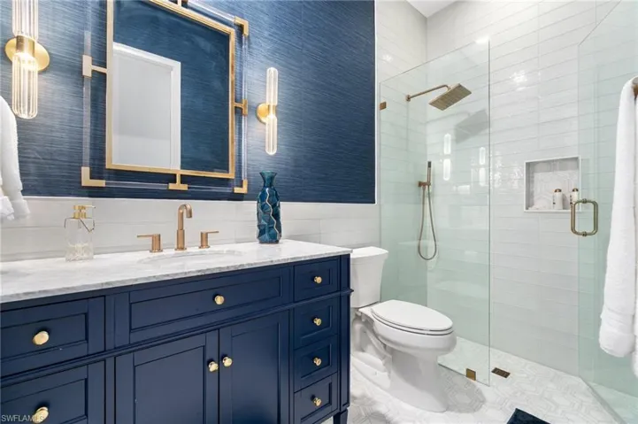 Custom vanity with a white countertop and gold-finish fixtures