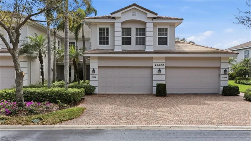 View of front of property featuring stucco siding, decorative driveway, a tiled roof, and a garage