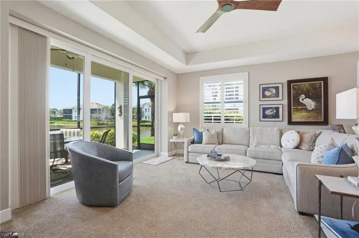 Living room featuring ceiling fan, carpet, and a water view