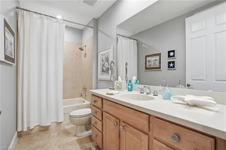 Full bathroom featuring vanity, shower / tub combo, and light tile patterned flooring