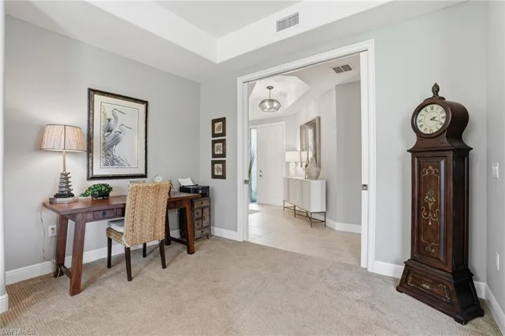 Home office with light colored carpet and baseboards