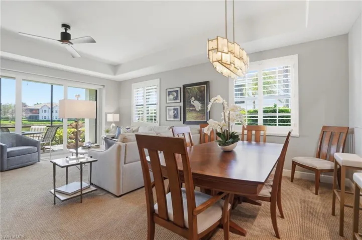 Dining space with carpet floors, a ceiling fan, and a tray ceiling