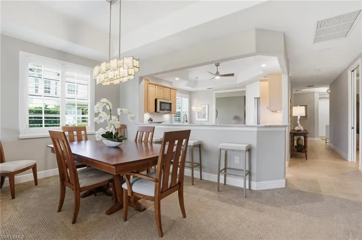 Dining space featuring a tray ceiling, light colored carpet, a ceiling fan, and recessed lighting