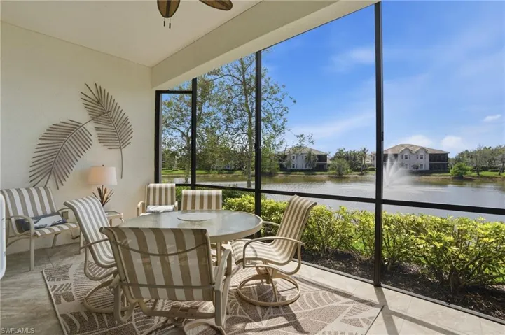 Sunroom / solarium with a water view, outdoor dining space, and ceiling fan