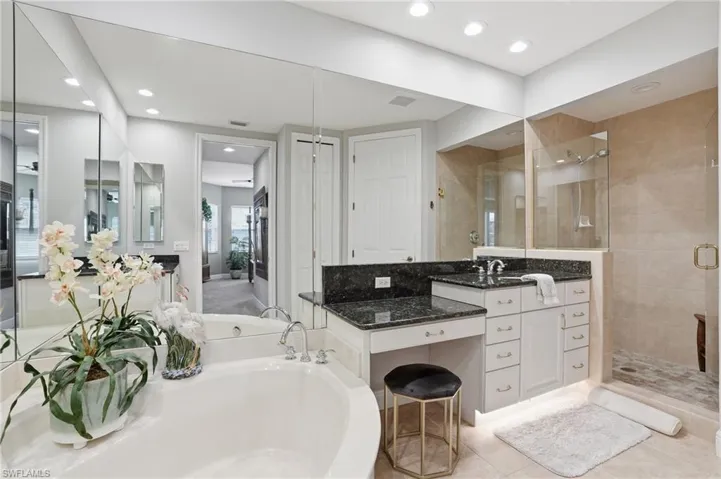 Full bathroom with vanity, a stall shower, a garden tub, and recessed lighting