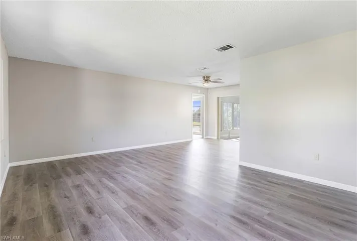 Spare room with hardwood / wood-style flooring, ceiling fan, and a textured ceiling