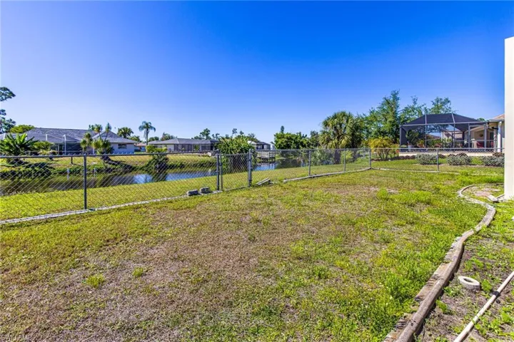 View of yard with a lanai and a water view