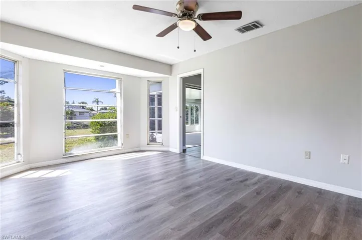 Spare room with ceiling fan and dark wood-type flooring